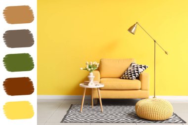 Sarı duvarın yanında koltuğu, masası ve lambası olan bir oturma odası. Farklı renk desenleri