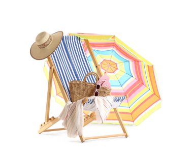 Renkli plaj şemsiyeli çizgili güverte sandalyesi ve beyaz arka planda izole edilmiş seyahat aksesuarları.