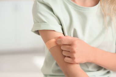 Klinikte aşıdan sonra tıbbî tedavi gören küçük kız, yakın plan.