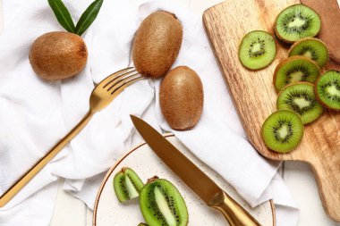 Tahta levha ve tabakta beyaz fayanslı taze kivi dilimleri.