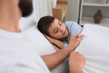 Evde uyuyan oğluyla pijamalı mutlu bir baba.