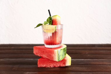 Bir bardak limonlu taze karpuz limonata ve ahşap masada nane.