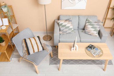 Modern oturma odası. Gri kanepe, koltuk ve masa.