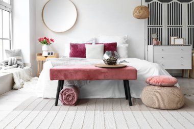 Pembe banklı ve aynalı aydınlık yatak odasının içi