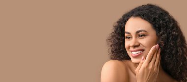 Güzel mutlu Afro-Amerikalı kadın bej arka planda sağlıklı tenli ve mesaj için yeri olan