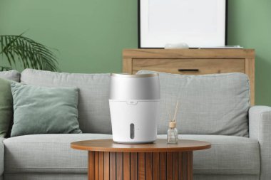 Oturma odasındaki masada hava nemlendirici var.