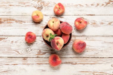 Tatlı incir şeftalili kase ve beyaz ahşap arka planda nane.