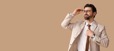 Bej arka planda şık takım elbiseli yakışıklı bir adam ve metin için yeri var.