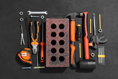 Siyah grunge arka planında tuğla ve inşaat araçları