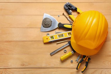 Ahşap arka planda sert şapka ve inşaat araçları