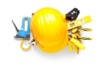 Beyaz arkaplanda sert şapka ve inşaat araçları