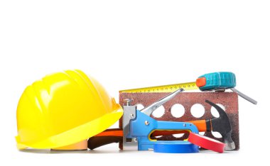 Beyaz arkaplanda sert şapka, tuğla ve inşaat araçları