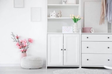 Anneler Günü için dekore edilmiş ışık odasının içi raf ünitesi ve çiçeklerle dolu.