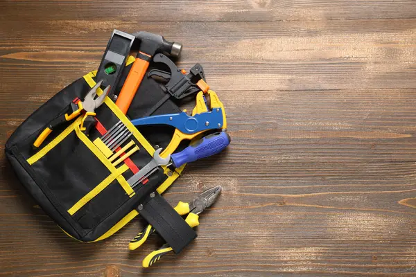 Ahşap arka planda inşaat aletleri olan çanta