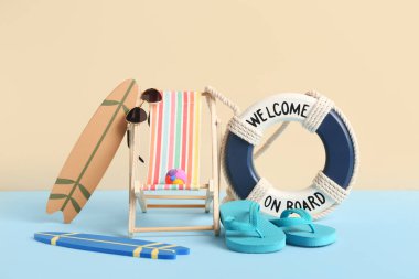 Güneş gözlüklü, sörf tahtalı, parmak arası terlikli ve renkli arkaplanda can simidi yüzüklü mini iskemle.