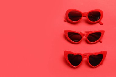 Renk arkaplanında farklı kırmızı güneş gözlükleri