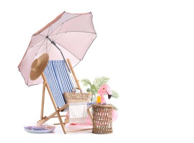 Plaj şemsiyeli çizgili güverte sandalyesi ve beyaz arka planda izole edilmiş seyahat aksesuarları.