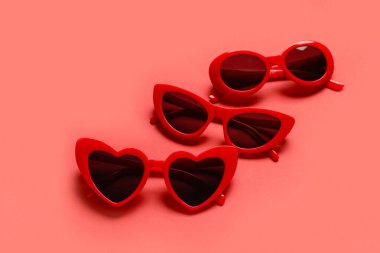 Renk arkaplanında farklı kırmızı güneş gözlükleri