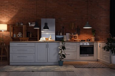 Geceleri mutfak tezgahları, raf üniteleri ve parlayan lambalarla dolu.