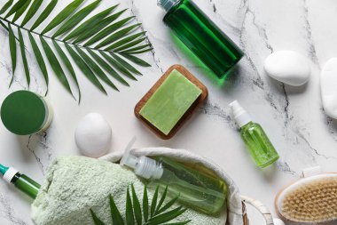 Beyaz arka planda farklı spa malzemeleri ve palmiye yaprakları olan hasır sepet.