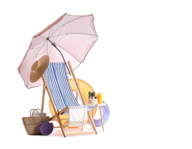 Plaj şemsiyeli çizgili güverte sandalyesi ve beyaz arka planda izole edilmiş seyahat aksesuarları.