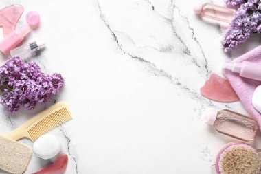 Farklı spa malzemeleri ve beyaz arka planda leylak çiçekleri olan güzel bir kompozisyon.