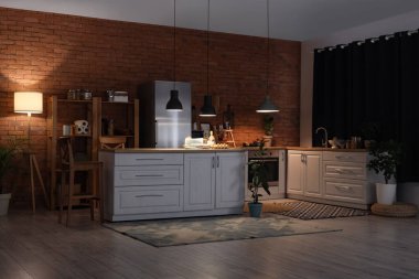 Geceleri mutfak tezgahları, raf üniteleri ve parlayan lambalarla dolu.