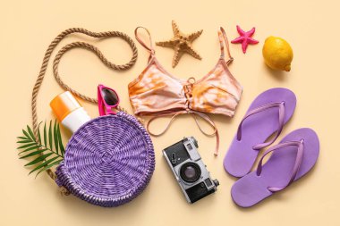 Bej arka planda mayolu, limonlu ve plaj aksesuarlı kompozisyon