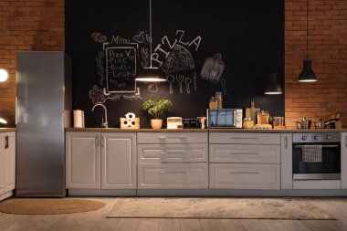 Tezgahları, tebeşir duvarları ve geceleri parlayan lambaları olan şık bir mutfak.