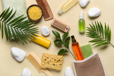 Bej arka planda farklı spa malzemeleri ve palmiye yapraklarıyla güzel bir kompozisyon.