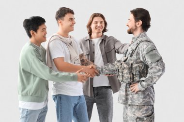 Mutlu arkadaşlar ve askerler hafif arka planda el sıkışıyor.