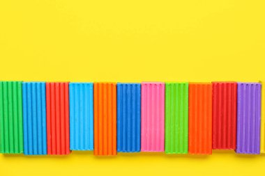 Sarı arkaplanda bir sürü renkli plastik var.