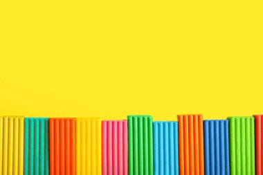 Sarı arka planda çok renkli plastikler, yakın plan