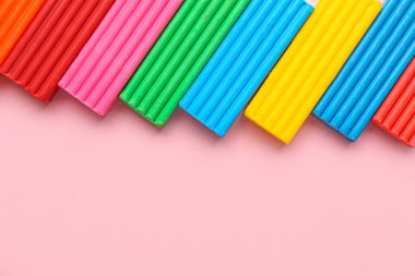 Pembe arka planda çok renkli plastikler, yakın plan.