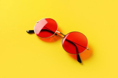 Sarı arkaplanda kırmızı güneş gözlüğü