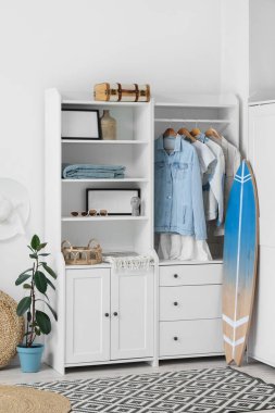 Sörf tahtası ve dolabı olan bir ışık odası.