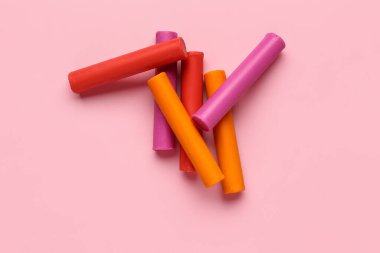 Pembe arka planda renkli plastikler