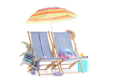 Renkli plaj şemsiyeli çizgili güverte sandalyeleri ve beyaz arka planda izole edilmiş seyahat aksesuarları.