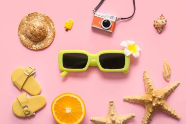 Pembe arka planda deniz yıldızları, turuncu ve dekoratif plaj aksesuarları, yakın plan.