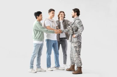 Mutlu arkadaşlar ve askerler hafif arka planda el sıkışıyor.