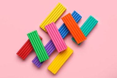 Pembe arka planda bir sürü renkli plastik var.