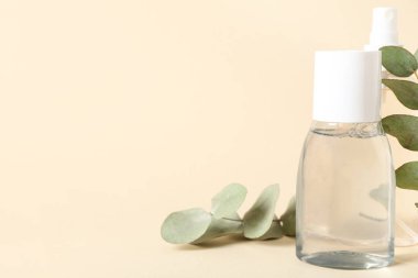 Su şişeleri ve bej arka planda yeşil dallar, yakın plan.