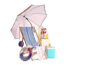Plaj şemsiyeli çizgili güverte sandalyesi, bavul ve beyaz arka planda izole edilmiş seyahat aksesuarları.