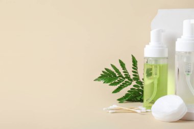 Su şişeleri, alçı tezgahı, bej arka planda pamuk ve tomurcuklar.