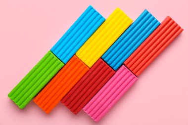 Pembe arka planda bir sürü renkli plastik var.