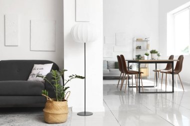 Oturma odasının içinde kanepeler, lamba ve yemek masası var.