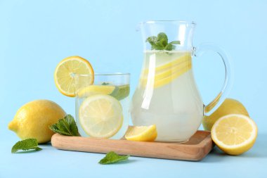 Mavi arka planda naneli bir bardak taze limonata.