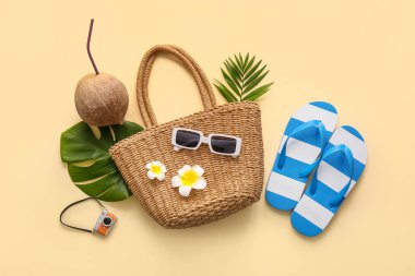 Hindistan cevizi, tropikal yapraklar ve bej arka planda plaj aksesuarları.