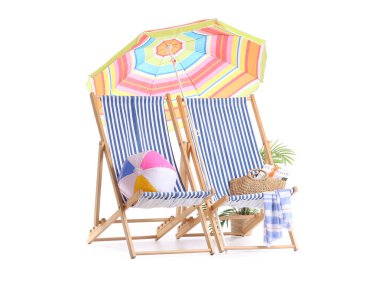 Renkli plaj şemsiyeli çizgili güverte sandalyeleri ve beyaz arka planda izole edilmiş seyahat aksesuarları.