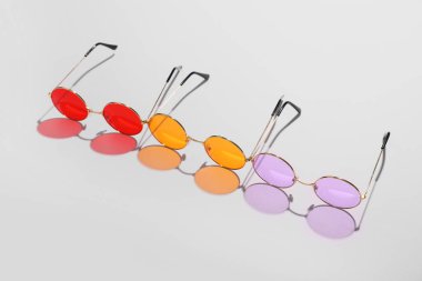 Gri arkaplanda renkli güneş gözlükleri